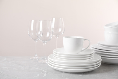 Photo of Set of clean tableware on light grey marble table