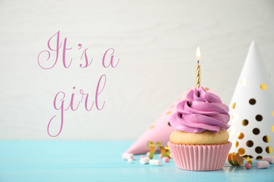 Image of Baby shower cupcake with candle for girl on light background