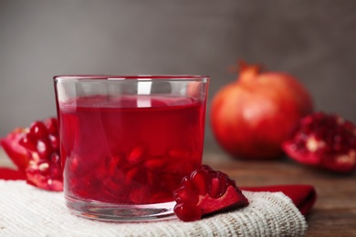 Photo of Glass of pomegranate jelly served on table, closeup. Space for text