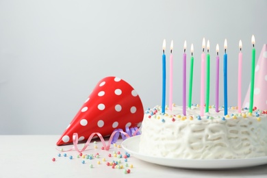 Photo of Delicious birthday cake with burning candles on table