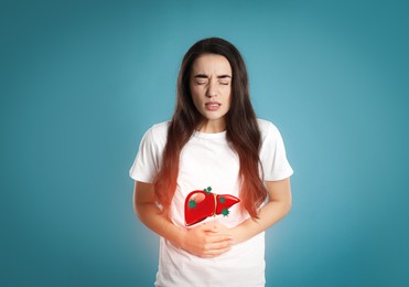 Image of Sick woman suffering from pain and illustration of unhealthy liver on light blue background. Viral hepatitis