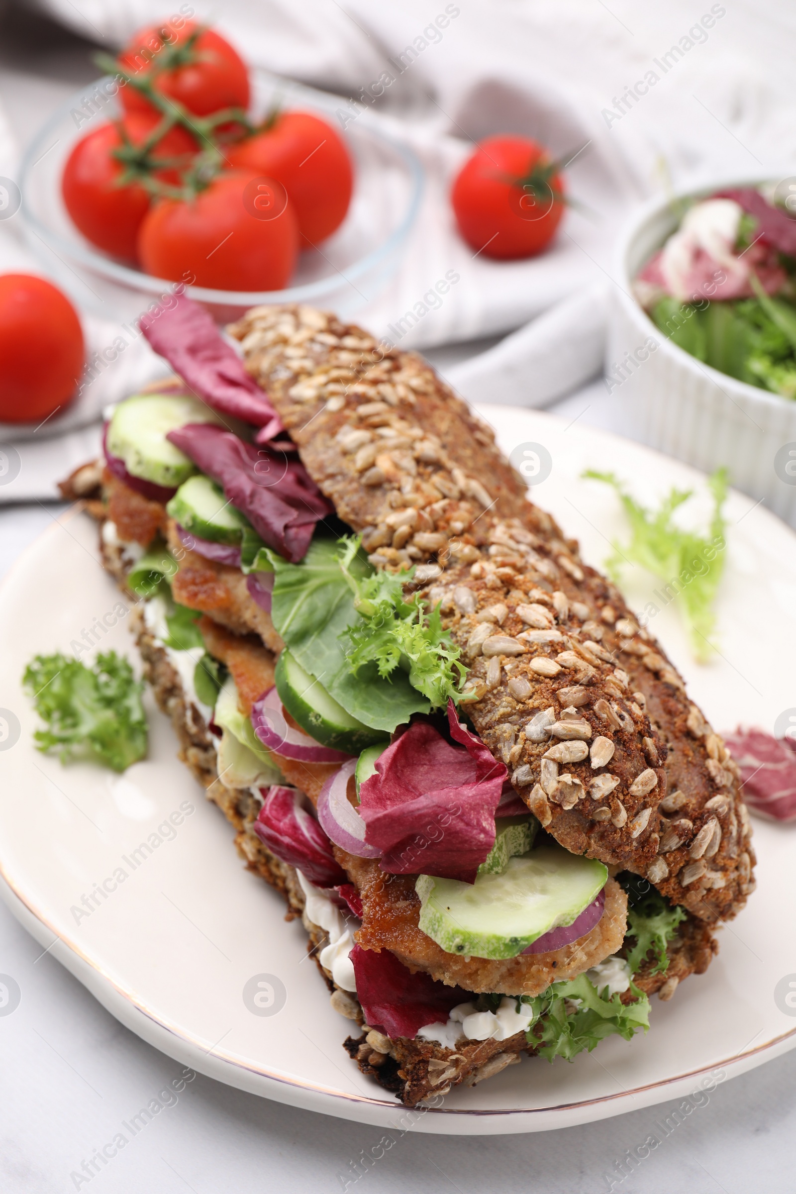 Delicious sandwich with schnitzel on white table, closeup Photo of Delicious sandwich with schnitzel on white table, closeup