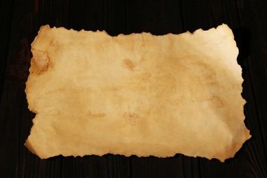 Photo of Sheet of old parchment paper on wooden table, above view