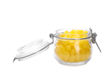 Photo of Tasty small lemon drops in glass jar isolated on white