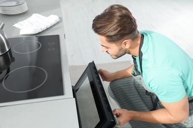 Photo of Young man baking something in oven at home