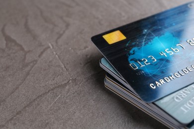 Photo of Credit cards on grey textured table, closeup. Space for text