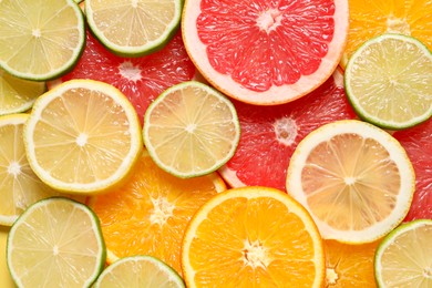 Photo of Different sliced citrus fruits as background, top view