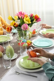 Photo of Festive table setting. Women celebrating Easter at home, closeup