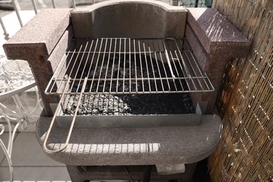 Photo of Empty barbecue grill with grid on outdoor terrace
