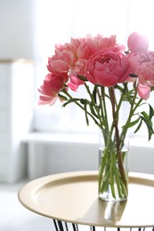 Photo of Beautiful bouquet of fragrant peonies in vase on table indoors