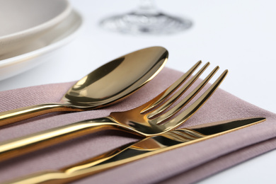 Photo of Stylish elegant cutlery set with napkin on white table, closeup