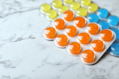 Photo of Blisters with color cough drops on marble background. Space for text