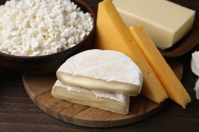 Photo of Dairy products. Different kinds of cheese and butter on wooden table, closeup