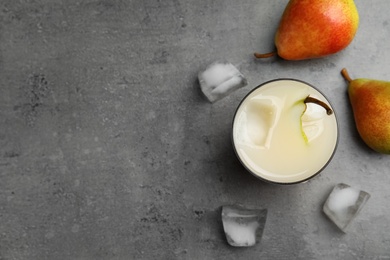 Photo of Fresh pear juice, ice cubes and fruits on grey table, flat lay. Space for text