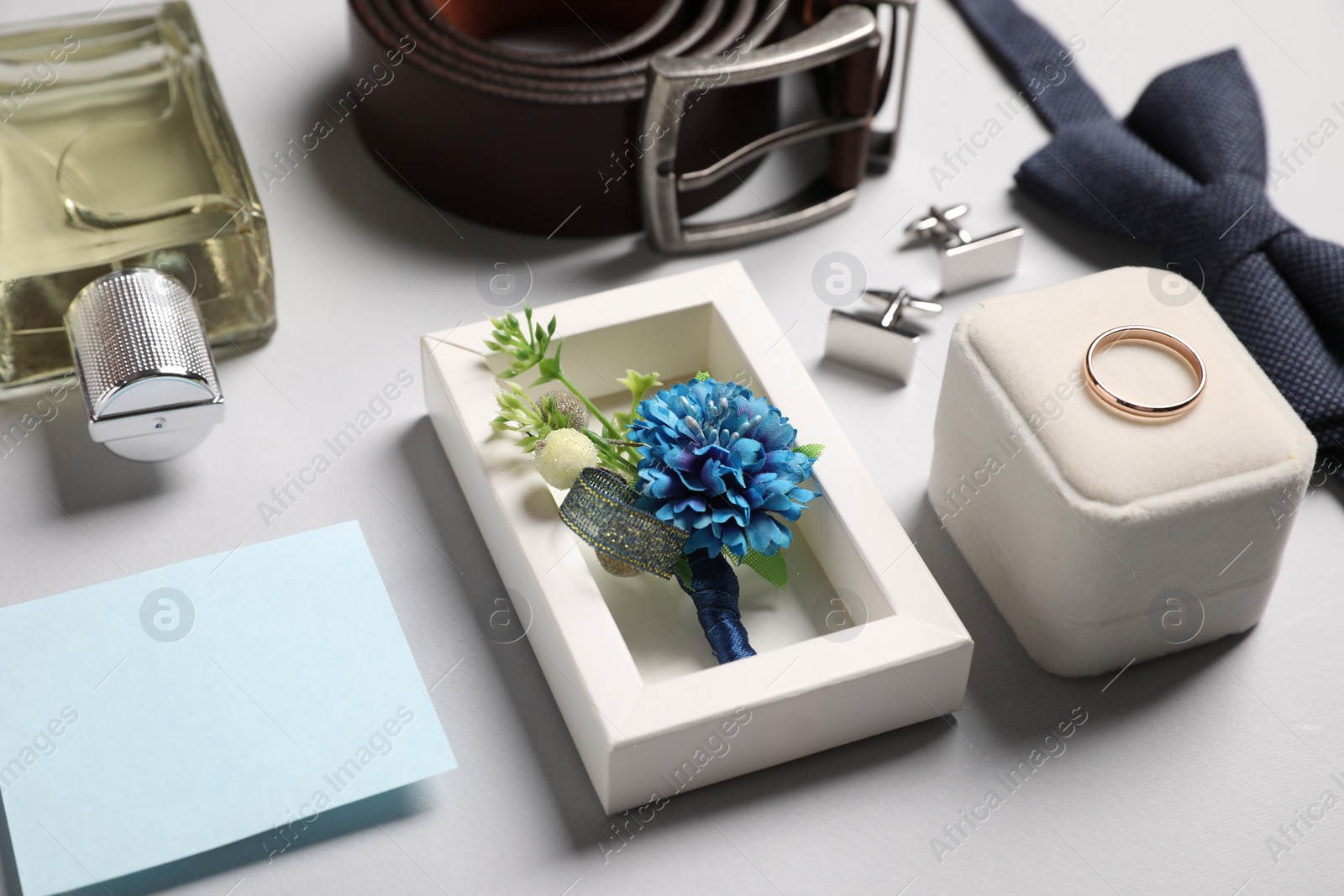 Photo of Wedding stuff. Composition with stylish boutonniere on light gray background, closeup