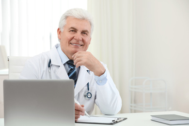 Photo of Portrait of senior doctor in white coat at workplace