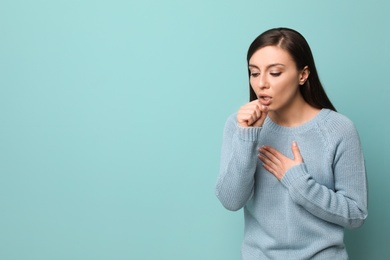 Photo of Young woman coughing on color background