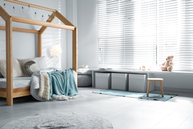 Photo of Cozy child room interior with comfortable bed