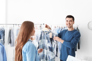 Young woman receiving her dress at dry-cleaner's