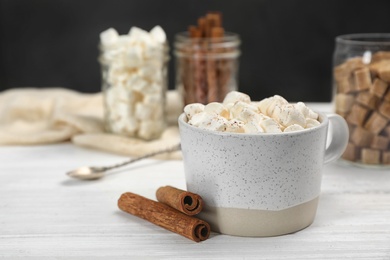 Photo of Cup of chocolate milk with marshmallows on wooden table