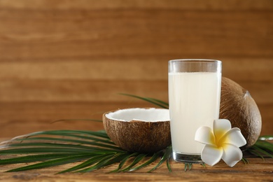 Photo of Composition with glass of coconut water on wooden background. Space for text