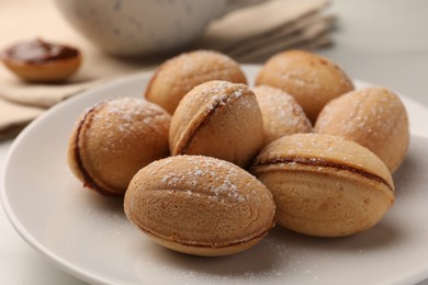 Photo of Homemade walnut shaped cookies with condensed milk on white table, closeup