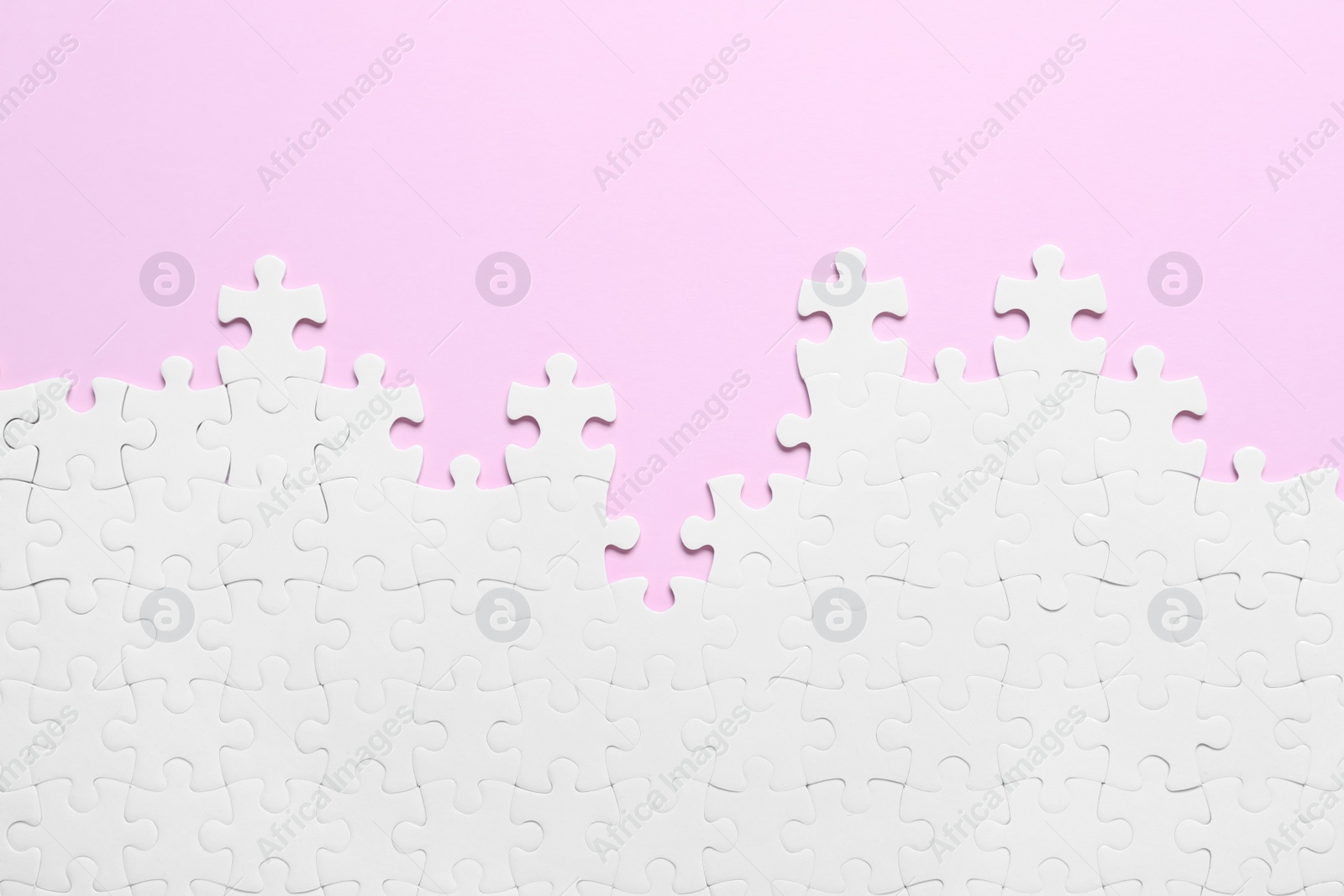 Photo of White puzzle on pink background, flat lay