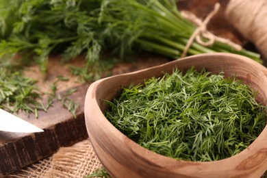 Photo of Fresh cut dill in bowl on table, closeup
