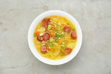 Photo of Delicious sauerkraut soup with smoked sausages and green onion on light grey table, top view