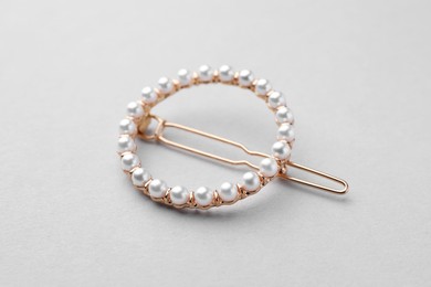Photo of Elegant pearl hair clip on white background