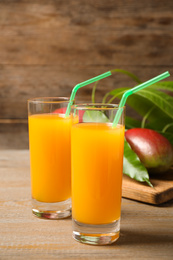 Photo of Fresh delicious mango drink on wooden table