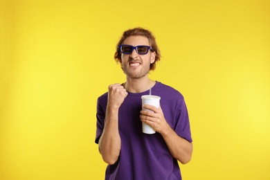 Photo of Emotional man with 3D glasses and beverage during cinema show on color background