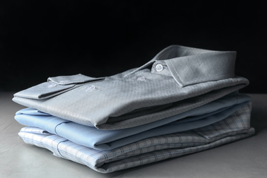 Photo of Stack of classic shirts on light stone table