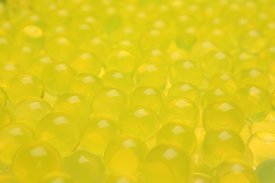Closeup view of yellow vase filler as background. Water beads