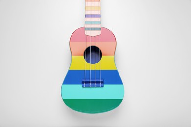 Photo of Colorful ukulele on white background, top view. String musical instrument