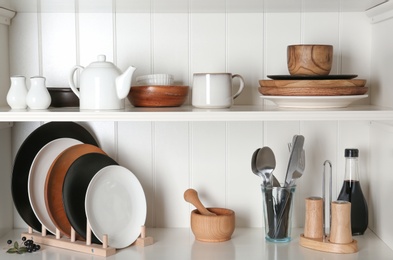 Photo of White shelving unit with set of dishware