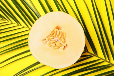 Photo of Flat lay composition with melon and tropical leaf on color background