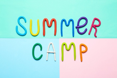 Photo of Text SUMMER CAMP made of modelling clay on color background, flat lay
