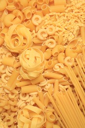 Photo of Different types of pasta as background, top view