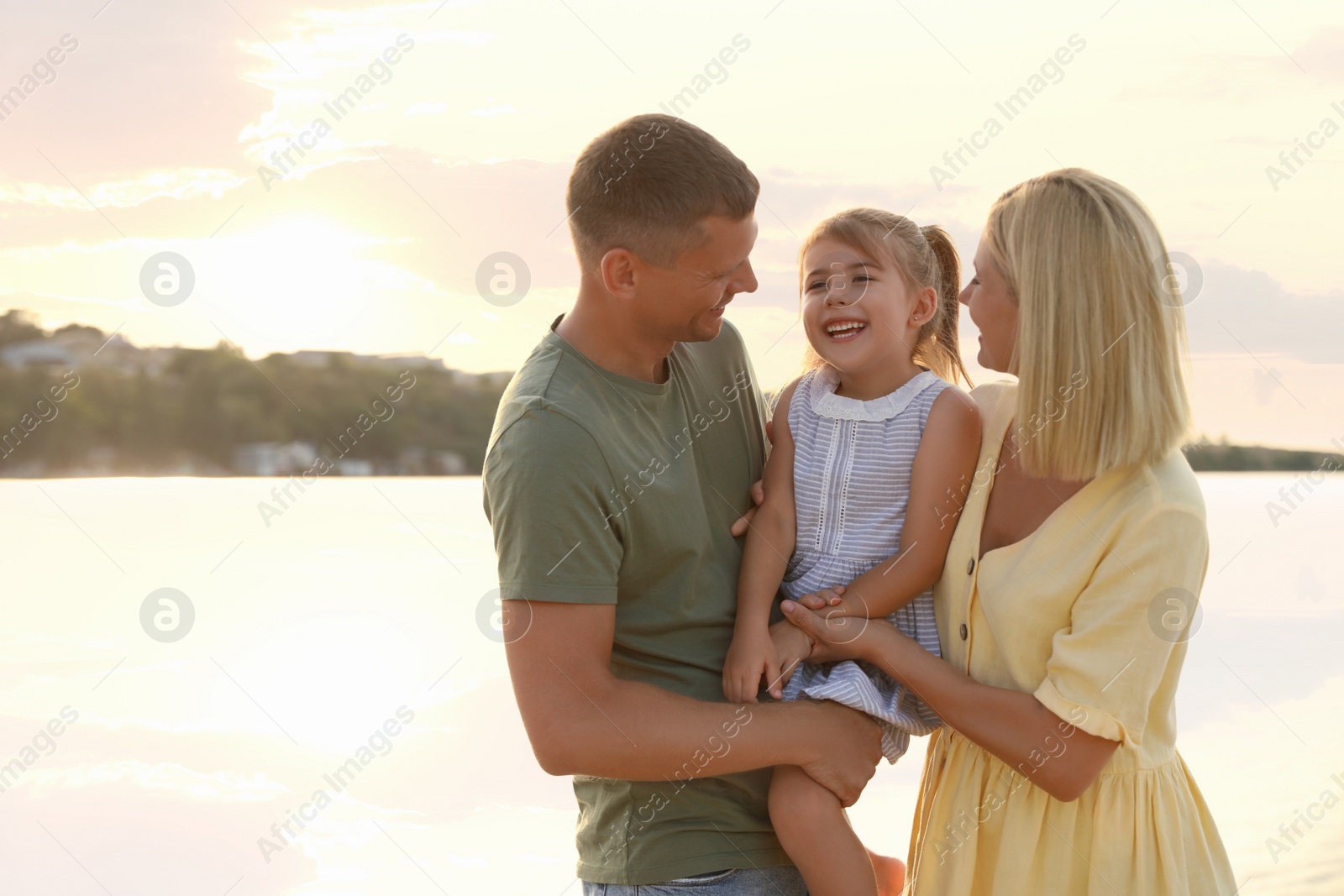 Photo of Happy parents with their child on beach, space for text. Spending time in nature