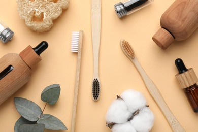 Photo of Flat lay composition with bamboo toothbrushes on pale orange background