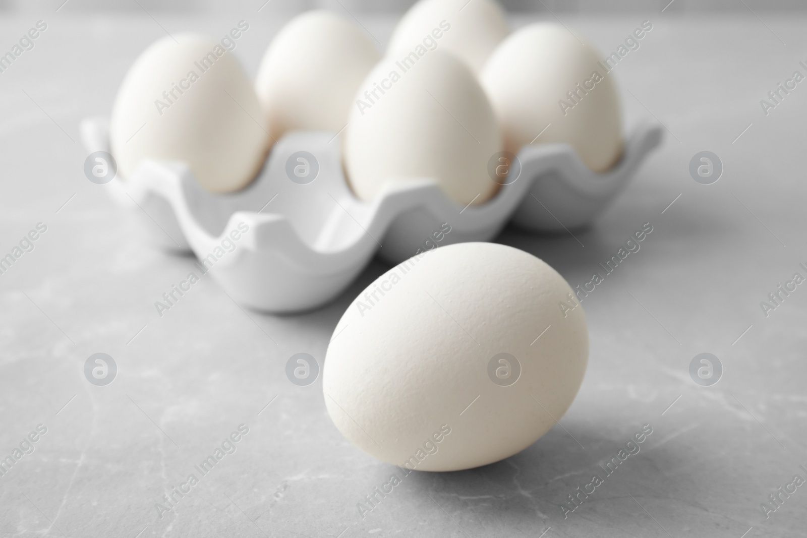 Photo of Raw chicken egg on light background, closeup