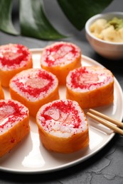 Photo of Delicious sushi rolls with salmon and tobiko on grey textured table, closeup
