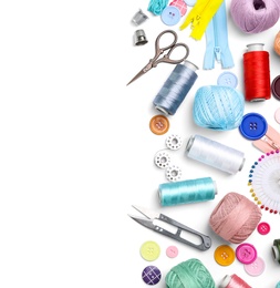 Composition with color threads and sewing accessories on white background, top view