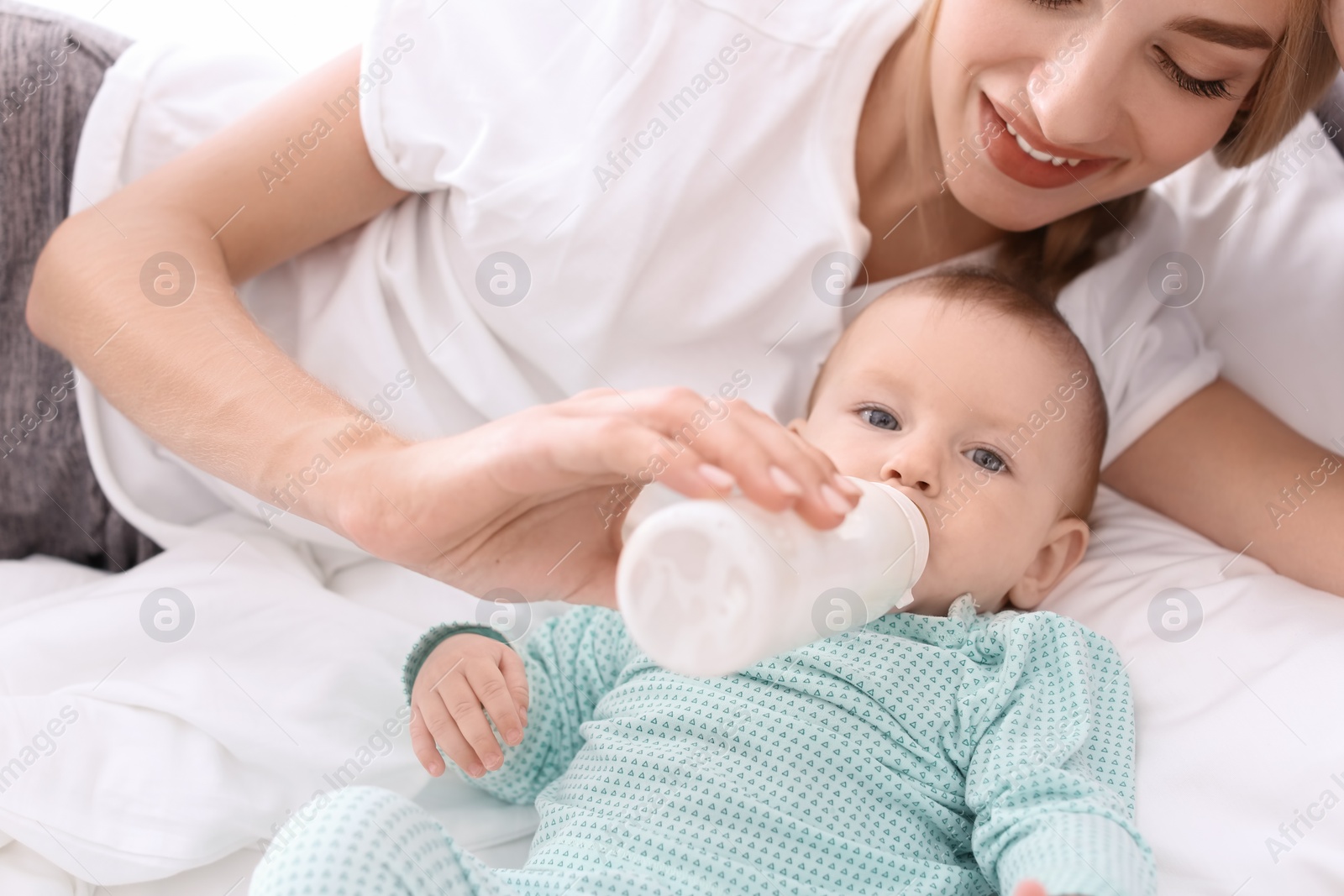 Photo of Woman feeding her child in bedroom. Healthy baby food