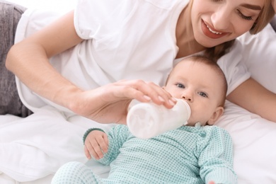 Woman feeding her child in bedroom. Healthy baby food