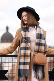 Photo of Beautiful woman in warm scarf and hat outdoors