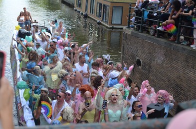 AMSTERDAM, NETHERLANDS - AUGUST 06, 2022: Many people in boat at LGBT pride parade on river