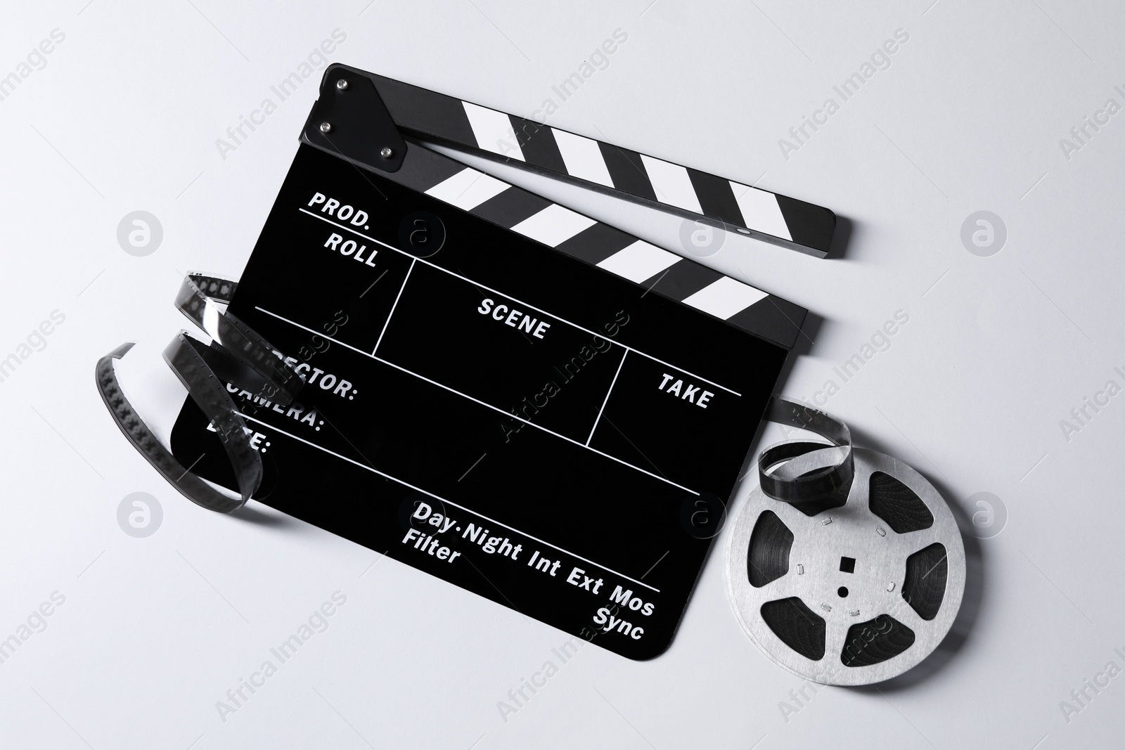 Photo of Clapperboard and film reel on grey background, flat lay