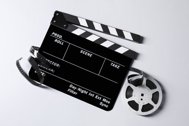 Photo of Clapperboard and film reel on grey background, flat lay